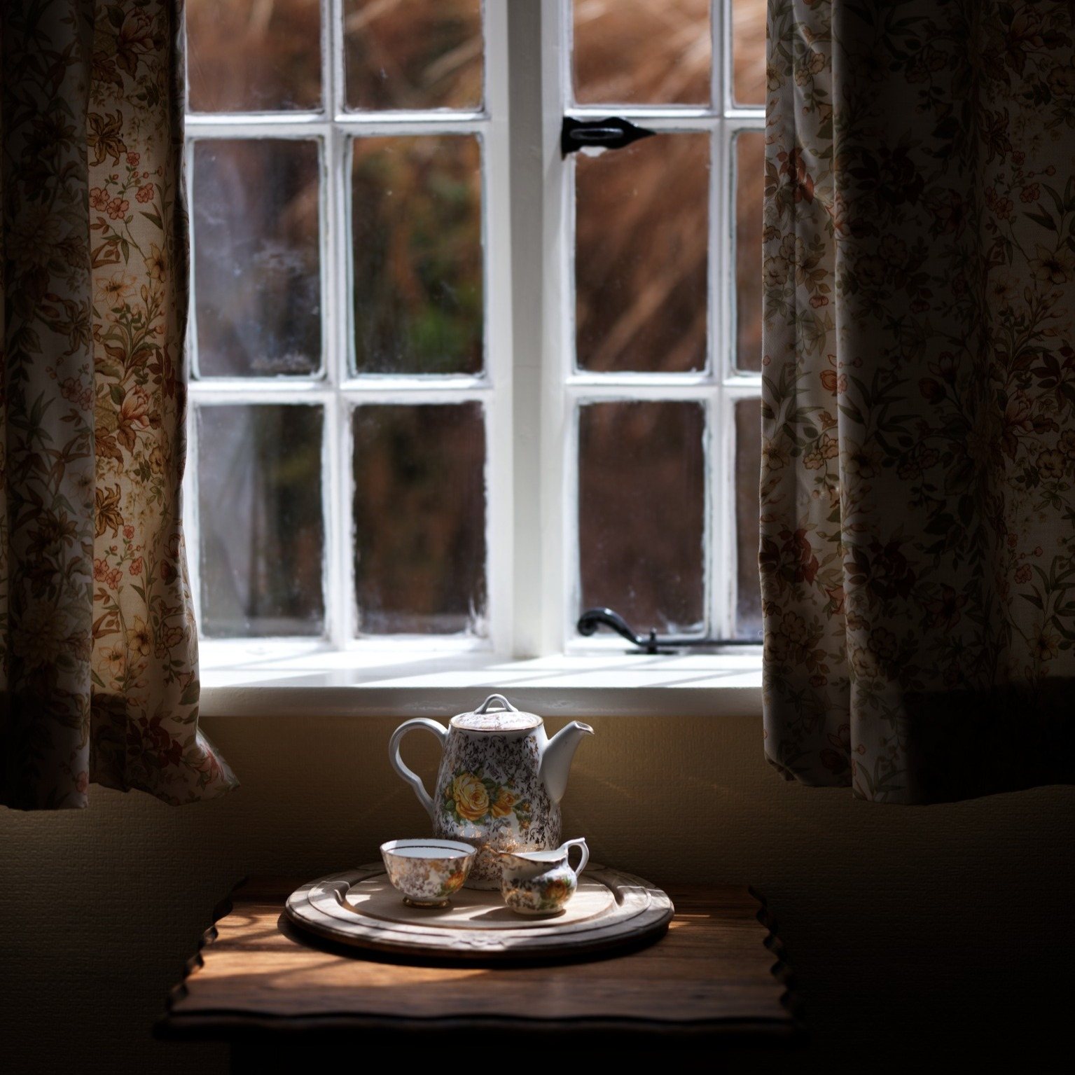 Teapot by a cottage window in soft light