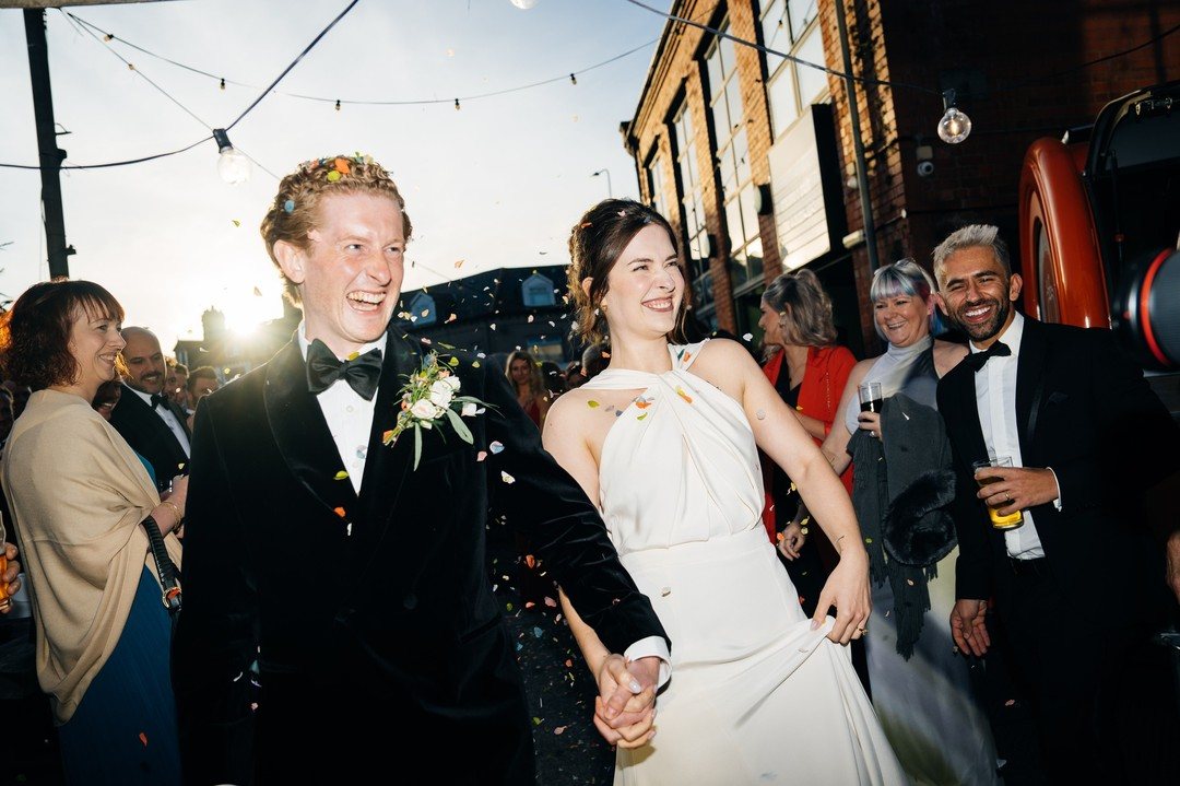Couple laughing under confetti at golden hour